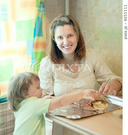 Happy mother with daughter cooking salmon Happy mother with daughter cooking salmon 9055111