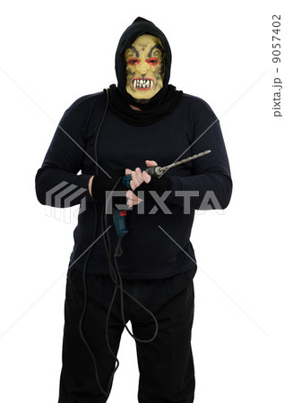 Maniac in a mask holds a electric drill 9057402