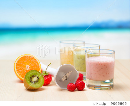 Fruit smoothie on wooden table on tropical beach Fruit smoothie on wooden table on tropical beach 9066666