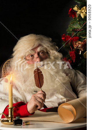 Santa Claus sitting at home and writing a letter 9068920