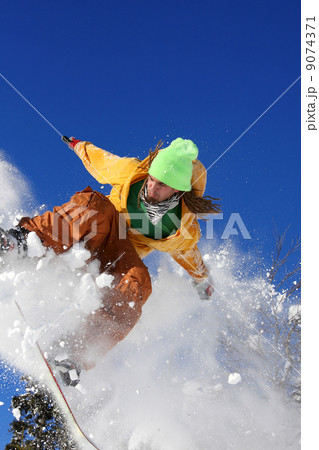 Snowboarder jumping against blue sky Snowboarder jumping against blue sky 9074371