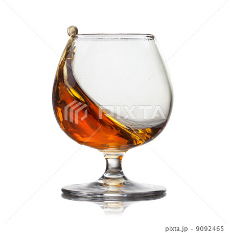 Splash of cognac in glass isolated on white background Splash of cognac in glass isolated on white background 9092465