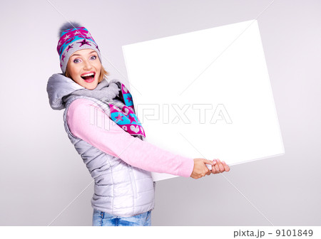 Adult smiling  woman in winter hat holds the white banner 9101849