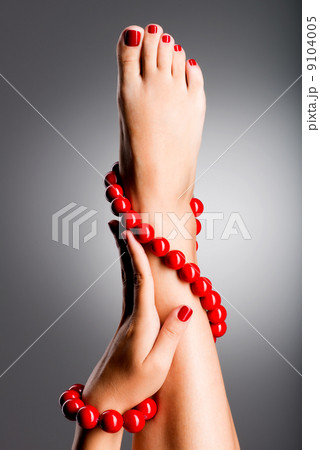 Closeup photo of a beautiful female feet with red pedicure Closeup photo of a beautiful female feet with red pedicure 9104005