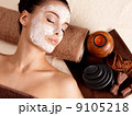 woman relaxing with facial mask on face at beauty salon 9105218