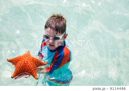 Little boy holding a giant starfish 9114486