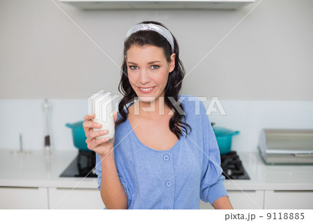 Smiling gorgeous model holding glass of milk 9118885