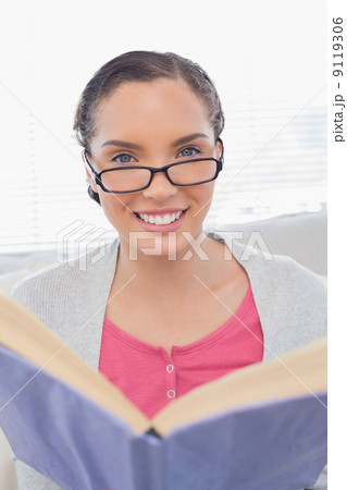 Smiling woman with reading glasses holding a book Smiling woman with reading glasses holding a book 9119306