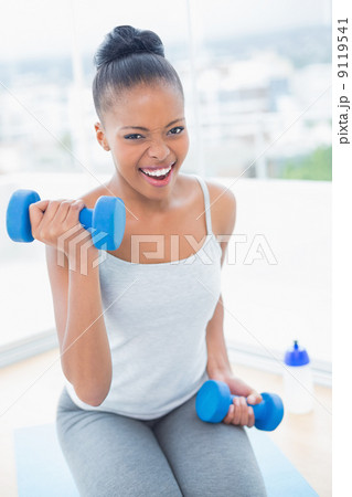 Exerted woman working out with dumbbell Exerted woman working out with dumbbell 9119541