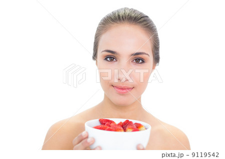 Smiling young brunette woman holding a bowl of strawberries 9119542