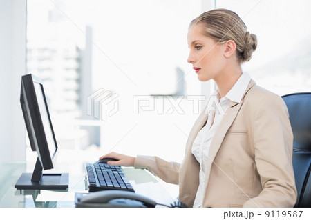 Peaceful blonde businesswoman working on computer Peaceful blonde businesswoman working on computer 9119587