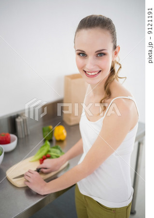 Happy young woman preparing vegetables smiling at camera 9121191