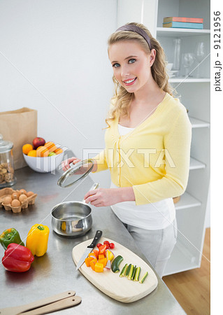 Smiling cute blonde holding cover of a pot 9121956
