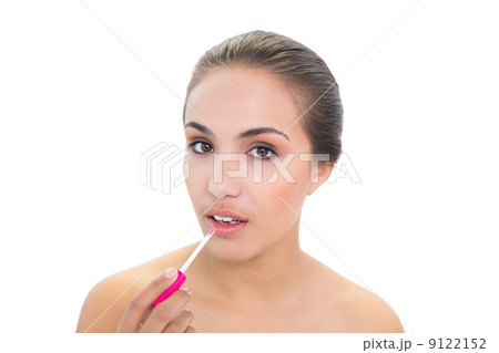 Lovely young brunette woman applying lip gloss 9122152