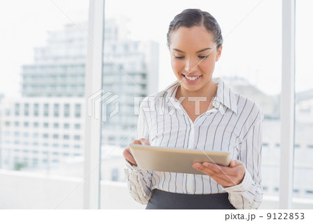 Attractive businesswoman using tablet pc Attractive businesswoman using tablet pc 9122853