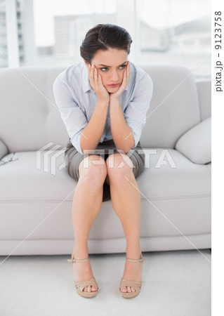 Elegant woman sitting with head in hands at home Elegant woman sitting with head in hands at home 9123758