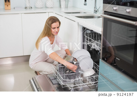 Happy gorgeous model kneeling behind dish washer Happy gorgeous model kneeling behind dish washer 9124197