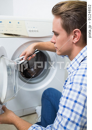 Technician repairing a washing machine 9124602