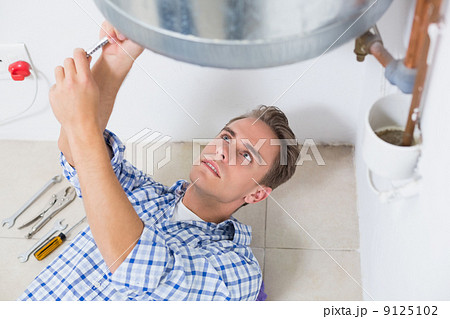 Technician servicing an hot water heater 9125102