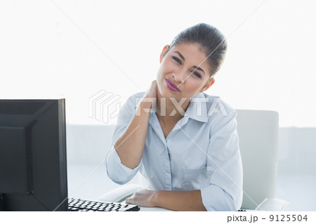 Businesswoman with neck pain in front of computer 9125504