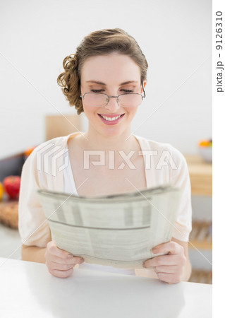 Beautiful young woman wearing glasses for reading newspaper Beautiful young woman wearing glasses for reading newspaper 9126310