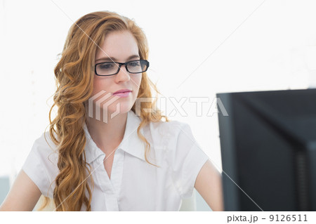 Serious businesswoman using computer in office 9126511