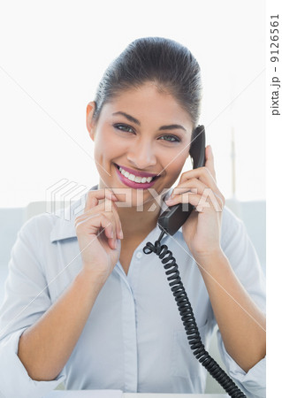 Portrait of a cheerful businesswoman using telephone Portrait of a cheerful businesswoman using telephone 9126561