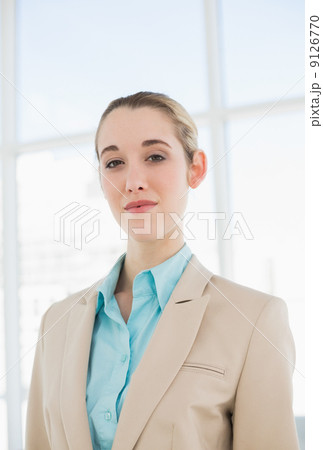 Lovely chic businesswoman posing seriously in her office 9126770