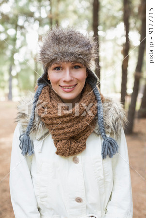 Woman wearing fur hat with woolen scarf and jacket in woods Woman wearing fur hat with woolen scarf and jacket in woods 9127215