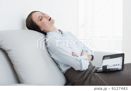 Well dressed woman sitting and sleeping on sofa 9127483