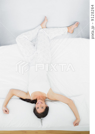 Full length of a woman lying in bed 9128264