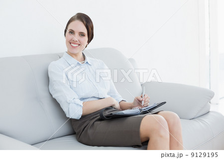 Well dressed woman using personal organizer at home 9129195