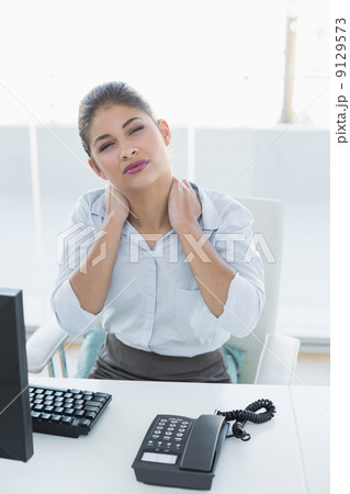Businesswoman with neck pain in front of computer Businesswoman with neck pain in front of computer 9129573