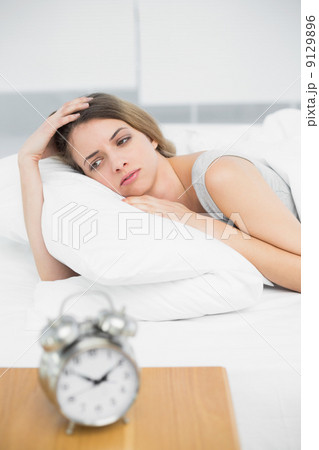 Gorgeous thinking woman lying on her bed under the cover Gorgeous thinking woman lying on her bed under the cover 9129896