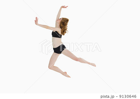 Full length side view of a sporty woman jumping Full length side view of a sporty woman jumping 9130646