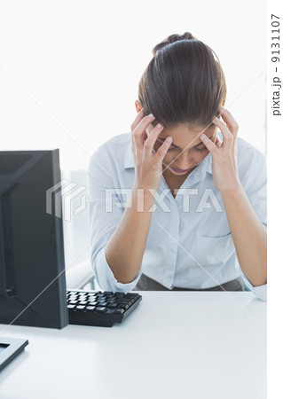 Businesswoman suffering from headache in front of computer Businesswoman suffering from headache in front of computer 9131107