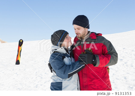 Happy loving couple with ski board on snow in background 9131353