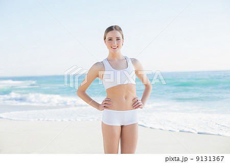 Smiling slender woman standing hands on hips Smiling slender woman standing hands on hips 9131367
