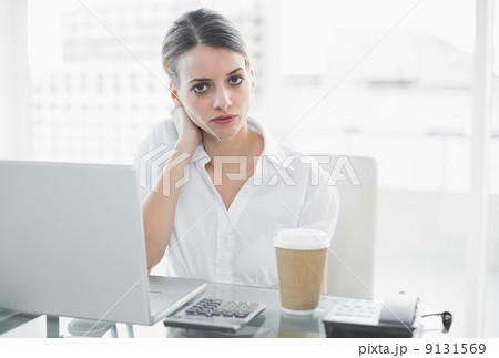 Calm serious businesswoman sitting at her desk 9131569
