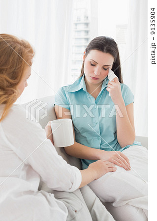Woman consoling a crying female friend at home 9135904