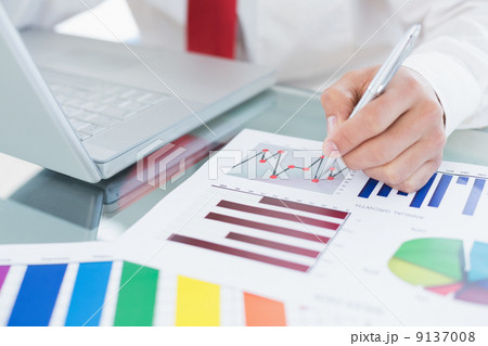 Mid section of a businessman with laptop and graphs Mid section of a businessman with laptop and graphs 9137008