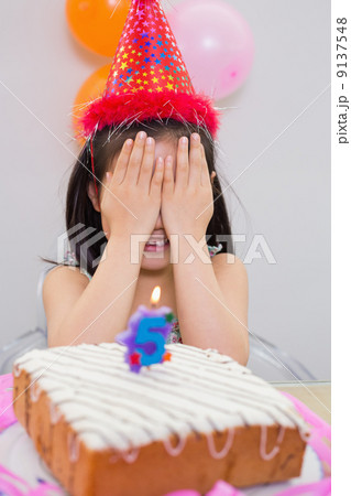Girl covering her face at the birthday party Girl covering her face at the birthday party 9137548