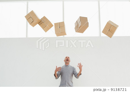 Annoyed mature man with falling boxes 9138721
