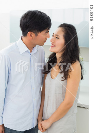 Side view of a romantic young couple in kitchen 9139431