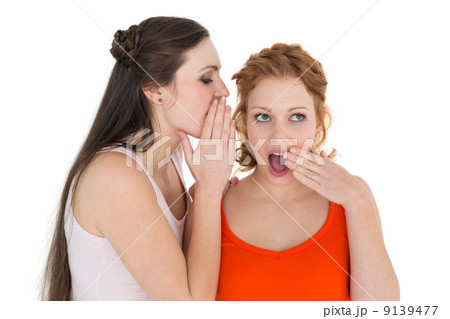 Two young female friends gossiping Two young female friends gossiping 9139477