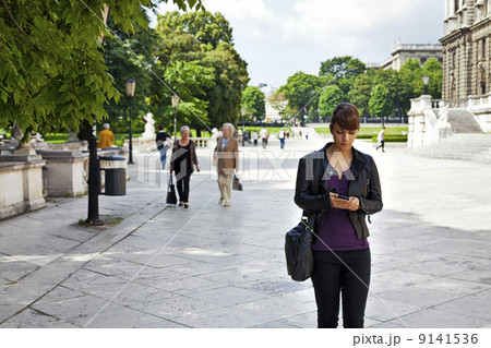 Smart and confident young woman striding through urban area 9141536