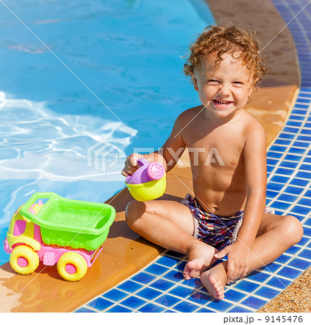 little boy playing near the pool little boy playing near the pool 9145476