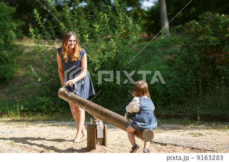Beautiful mother and little daughter on playground Beautiful mother and little daughter on playground 9163283