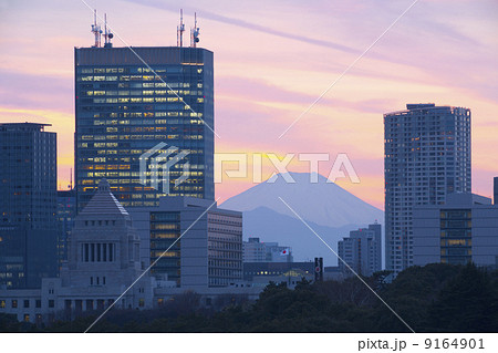 東京都心から望むきれいな夕焼けの富士山と国会議事堂・高層ビル群 9164901