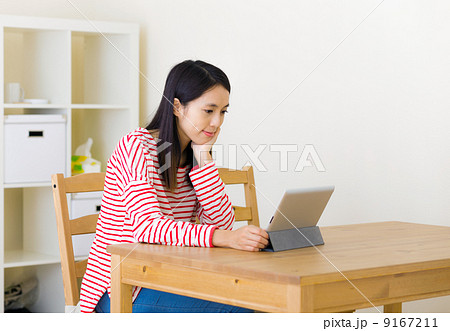 Asian woman watching movie on tablet Asian woman watching movie on tablet 9167211